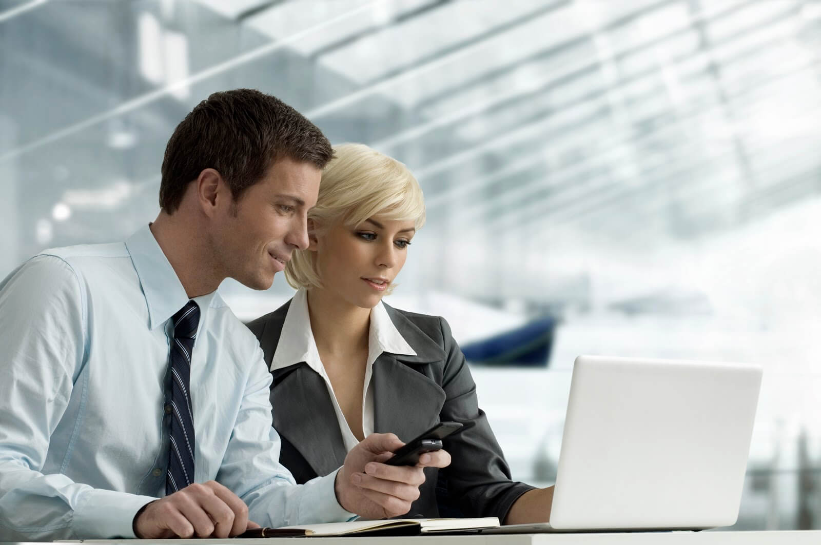 a male and female coworkers looking at a laptop