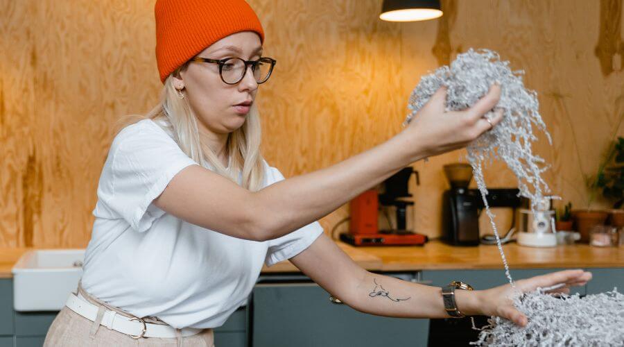 Woman taking shredded paper out of a box